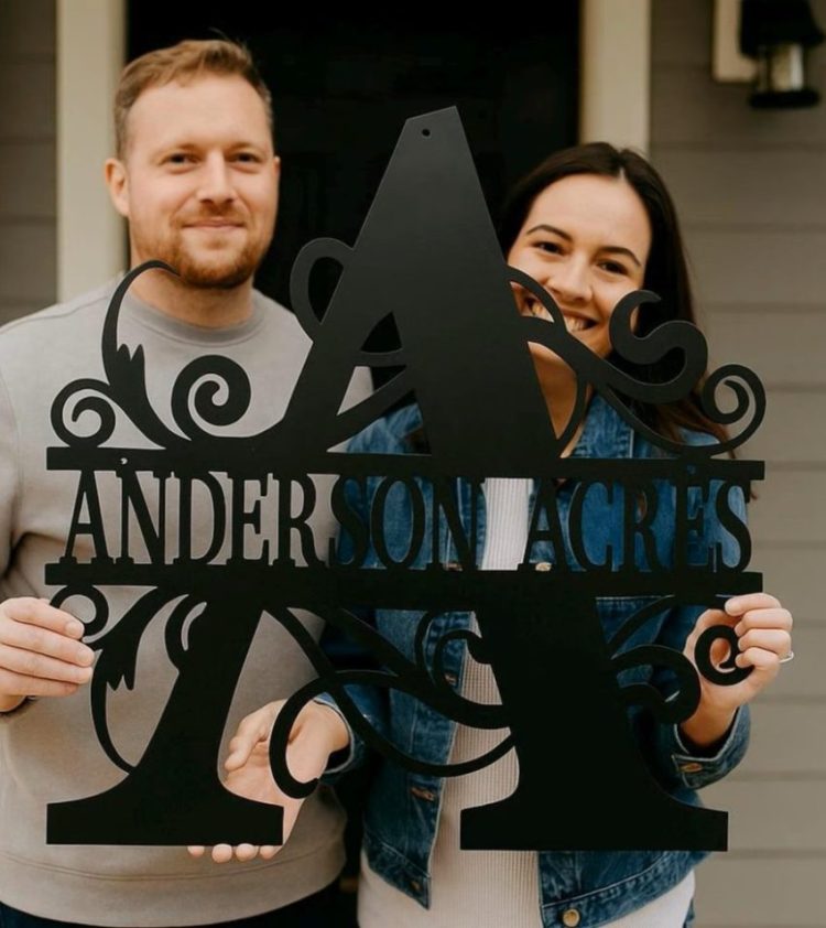 happy couple holding custom metal decor monogram sign